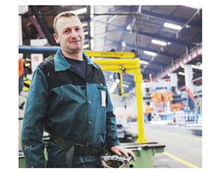 Image of Worker standing in front of a forklift